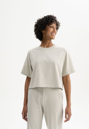 Lichtgrijs cropped t-shirt van zachte stof, met korte mouwen en een ronde halslijn, gecombineerd met bijpassende broeken.