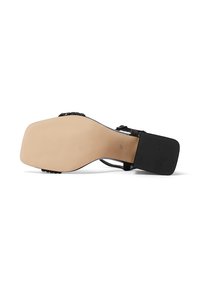 Sandal con tacco nero caratterizzata da una tomaia in pelle liscia, accenti neri testurizzati e una suola in gomma beige con un design di grip decorato.