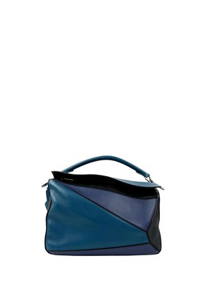 Sac à main en cuir bleu et noir à motif géométrique, avec poignée supérieure et rabat ouvert, montrant une poche intérieure sur fond blanc.