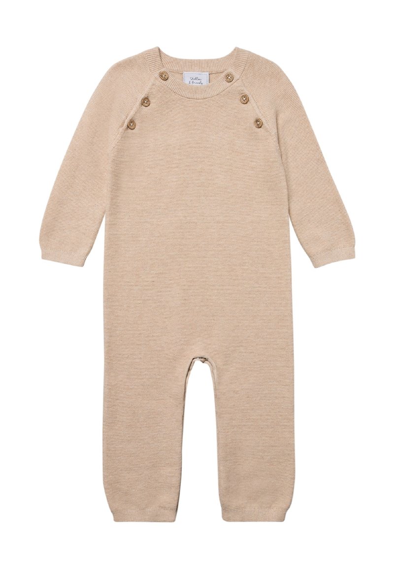 Beige gebreide jumpsuit met lange mouwen, voorzien van vijf knopen op de schouder, geribde manchetten en een relaxte pasvorm. Glad textuur over het geheel.