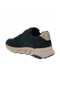 Sneaker in suede blu navy con tallone beige e suola imbottita. Presenta un design curvo, lacci piatti e un motivo testurizzato sulla suola.