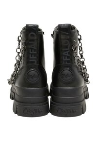 Bottes noires épaisses à semelles épaisses, marquées "Buffalo" au talon et à la semelle, avec des chaînes noires et des languettes portant le texte "Buffalo".