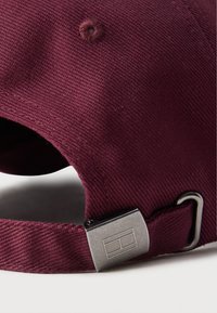 Bordo puuvillane nokamüts tekstuurse pinnaga, mille tagaosas on metallist klamber ja peal ümmargune ventilatsiooniauk.