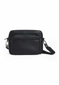 Bolso de cuero negro tipo bandolera con bolsillo frontal con cremallera, textura suave, forma rectangular, correa ajustable y acentos en metal.