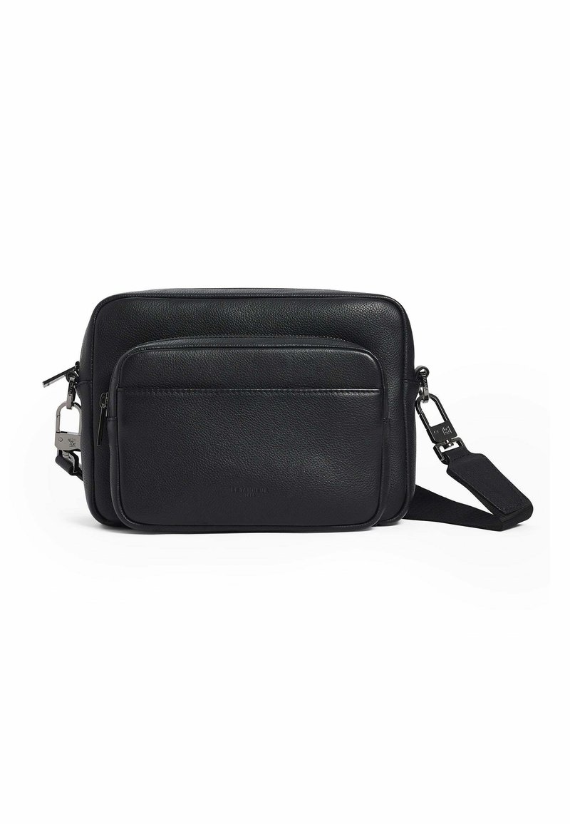 Bolso de cuero negro tipo bandolera con bolsillo frontal con cremallera, textura suave, forma rectangular, correa ajustable y acentos en metal.