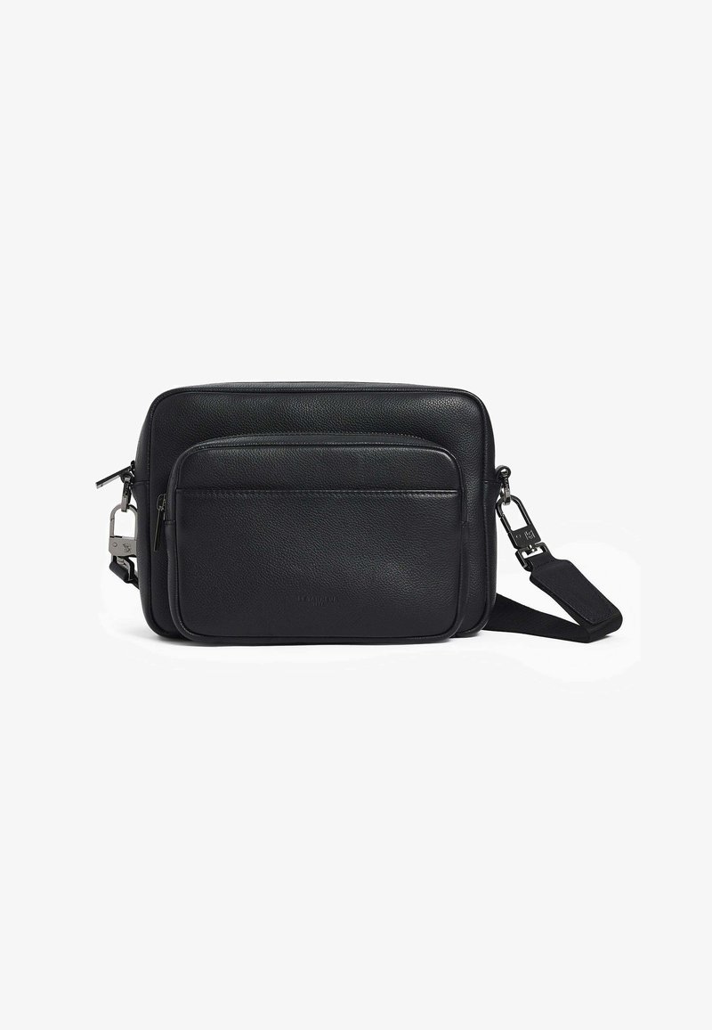 Bolso de cuero negro tipo bandolera con bolsillo frontal con cremallera, textura suave, forma rectangular, correa ajustable y acentos en metal.