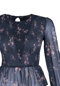 Marineblå kjole med blomsterprint i pink. Har smocket bodice, lange gennemsigtige ærmer og en peplum kant. Nøgne-hul rygdetalje.