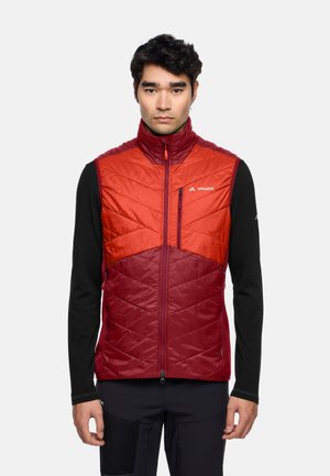 Gilet isolé rouge et rouge foncé avec un col haut, un design matelassé, une poche poitrine zippée et un logo sur le côté gauche.