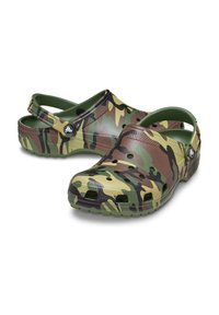 Klompen met camouflagepatroon, gemaakt van een glad, flexibel materiaal, met een achterband en ventilatiegaten op een gemodelleerde zool voor grip en comfort.