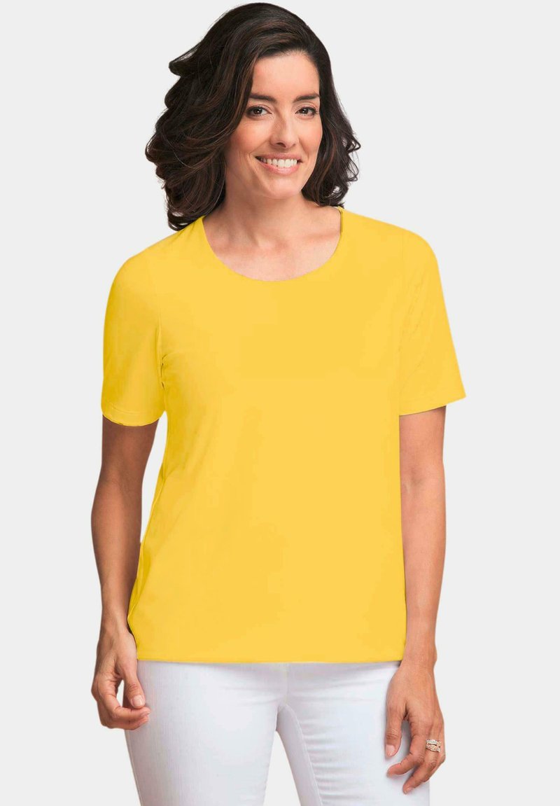 Short-sleeve yellow t-shirt with a round neckline, made of smooth fabric, paired with white pants. Minimal design, no patterns or accents.