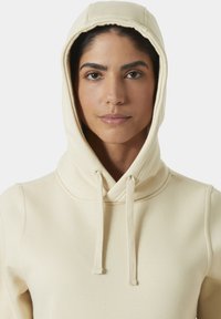 Beige hooded sweatshirt met een zachte textuur, trekkoorden bij de halslijn en een aansluitend ontwerp. Heeft een ronde capuchon en een minimalistische stijl.