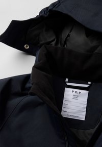Laivaston takki mustalla fleece-kauluksella, etu vetoketjulla, sisämerkintänä koko T.116 ja sileä, vettä hylkivä kangas.