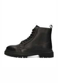 Botas de cuero negras hasta el tobillo con un acabado texturizado, puntera redonda, cordones frontales y una suela gruesa y robusta. Cuenta con un tirador en el talón.