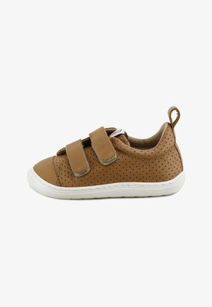 Zapato infantil marrón de cuero perforado con dos tiras de velcro y una suela de goma blanca, mostrado de lado.