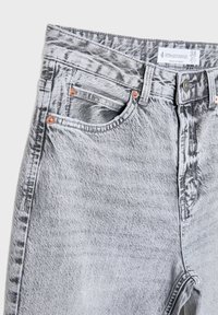 Jean taille haute gris clair délavé à l'acide avec poches avant, rivets en cuivre, passants de ceinture et étiquette Stradivarius taille 38 à la taille.