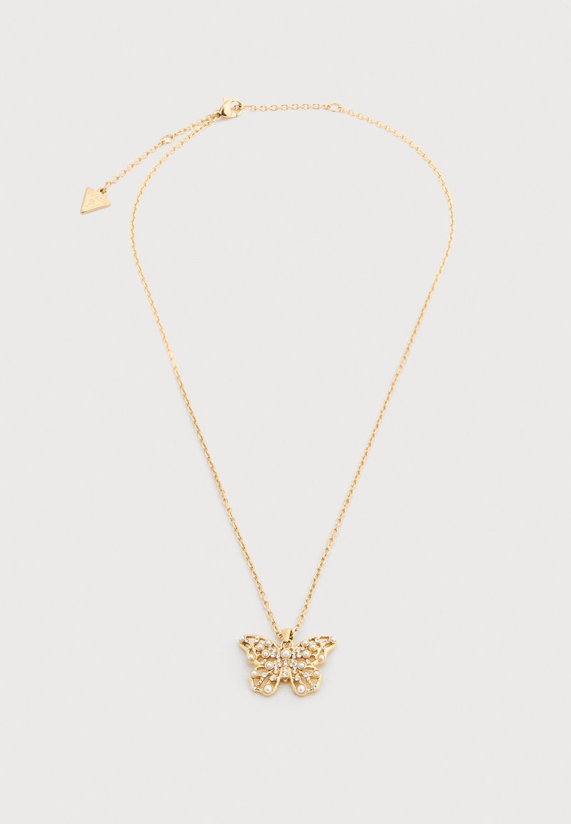 Εύθραυστο χρυσό κολιέ αλυσίδα με μενταγιόν πεταλούδα διακοσμημένο με μικρές πέρλες και κρύσταλλα σε απλό ανοιχτό φόντο.