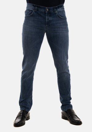 Jeans in denim blu con una vestibilità slim, dotati di cinque tasche, chiusura con bottone e leggere sfumature sul davanti. Abbinati a scarpe eleganti nere.