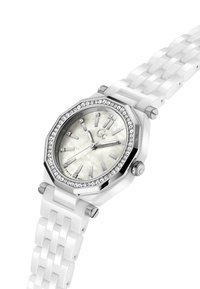Reloj de cerámica blanca con bisel octagonal de plata, acentos de cristal y una esfera de nácar. Presenta marcadores de hora plateados y un robusto cierre.