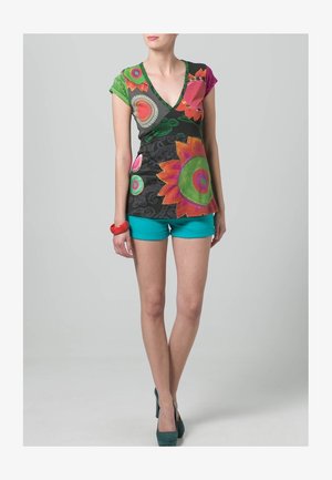 Top multicolor con escote en V y patrones florales en verde, rosa y naranja, combinado con pantalones cortos color verde azulado y tacones verdes. Tela suave, mangas cortas.