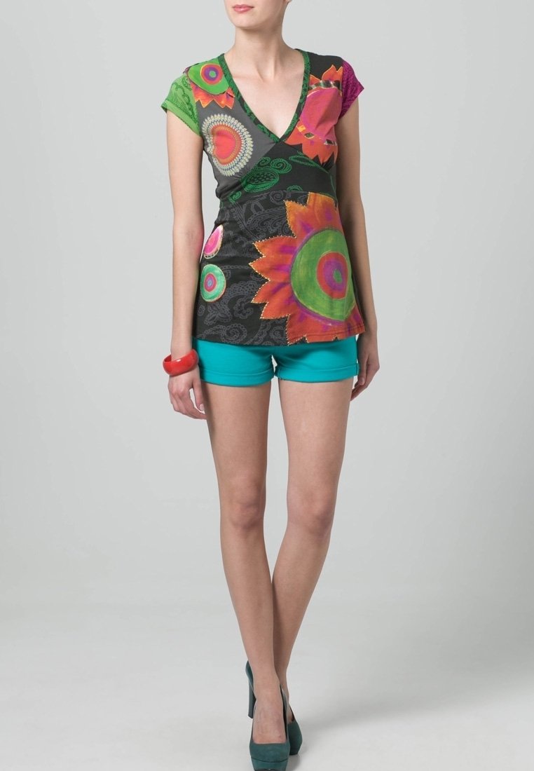 Vícebarevný top s výstřihem do V a květinovými vzory v zelené, růžové a oranžové barvě, kombinovaný s tyrkysovými šortkami a zelenými podpatky. Měkká látka, krátké rukávy.