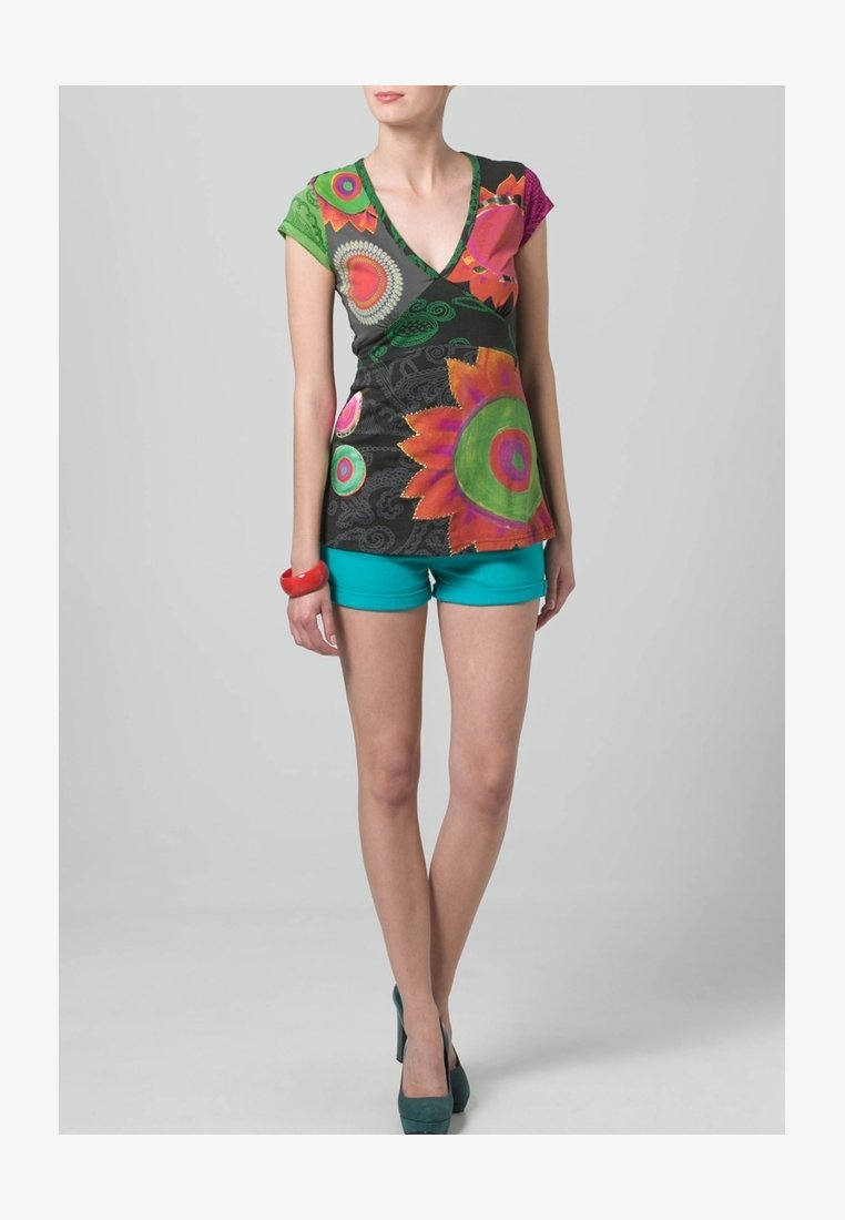 Vícebarevný top s výstřihem do V a květinovými vzory v zelené, růžové a oranžové barvě, kombinovaný s tyrkysovými šortkami a zelenými podpatky. Měkká látka, krátké rukávy.