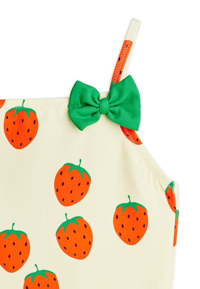 Υφασμα σε κρεμ απόχρωση με πορτοκαλί εκτυπώσεις φράουλας, λεπτές ραντάκια και ένα χαρακτηριστικό πράσινο φιόγκο κοντά στη σύνδεση του ραντακιού.
