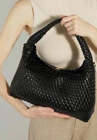 Zwarte geweven handtas met een ronde vorm. Heeft een gestructureerd oppervlak, een gevlochten handvat en een glanzend gouden accent aan de zijkant.