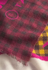 Geruite sjaal in tinten van bordeauxrood en donkergrijs met gele en roze accenten. Zachte, gestructureerde stof met franjes aan de randen.