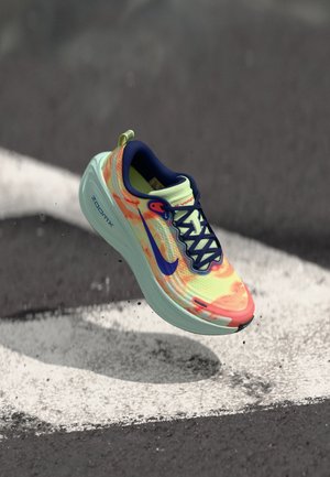 Nike ZoomX skriešanas apavi dzīvīgās oranžā, dzeltenā un zilā krāsā. Aprīkoti ar elpojošu sieta augšdaļu, mīkstinātu zolīti un melnām auklām.
