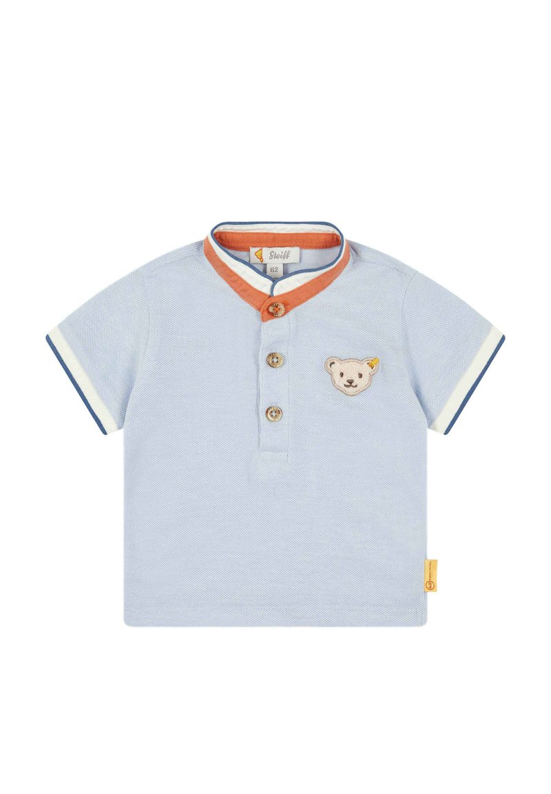 Lichtblauwe polo met korte mouwen en oranje kraagafwerking, voorzien van drie houten knopen en een geborduurd berenmotief op de borst.