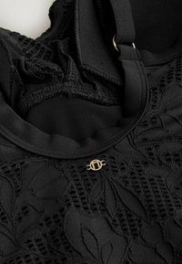 Indumento nero con intricato motivo in pizzo floreale, realizzato in tessuto morbido e elasticizzato, con un dettaglio dorato. Cinghie regolabili incluse.
