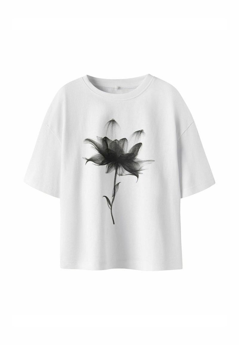 T-shirt blanc en coton avec un imprimé graphique floral noir. Le t-shirt a un col rond et des manches courtes et amples.