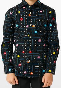 Camicia nera con bottoni, caratterizzata da un design colorato ispirato al labirinto di Pac-Man, che include fantasmi e pallini. Tessuto di cotone, con maniche lunghe e colletto.