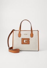Sac à main en toile beige avec des accents et des poignées en cuir brun. Présente un logo "G" en relief bien visible sur le devant et une bandoulière amovible.