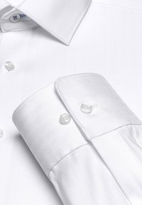 White herringbone patterned shirt collar and cuff with button closures, made from textured fabric. Features smooth white buttons.