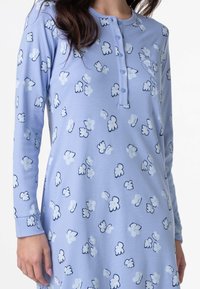 Nightdress lungo azzurro chiaro con maniche lunghe e scollo a henley con bottoni, caratterizzato da un motivo floreale in bianco e dettagli blu navy. Tessuto morbido.