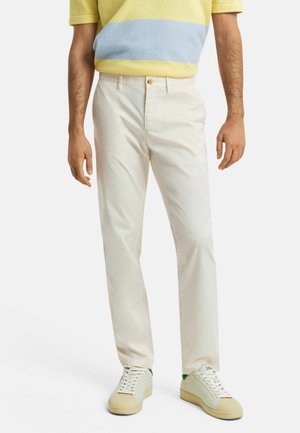 Lichtgekleurde katoen chinos met een slanke pasvorm. Voorzien van een knoopsluiting aan de voorkant, zakken en gecombineerd met off-white sneakers.