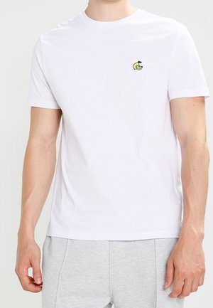 Weißes Baumwoll-T-Shirt mit kleinem gelb-grünem Zitronenmotiv auf der linken Brust. Rundhalsausschnitt und kurze Ärmel.