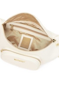 Interno di una borsa in pelle bianca con fodera beige. Presenta una tasca con zip e un'etichetta con logo dorato. Texture liscia con cuciture visibili.