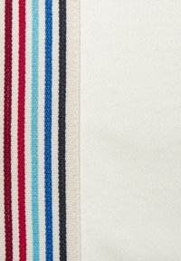 Baumwollstoffabschnitt mit wechselnden Streifen in Rot, Blau und Marineblau auf einem weißen Hintergrund; glatte Textur und gleichmäßige Nähte.