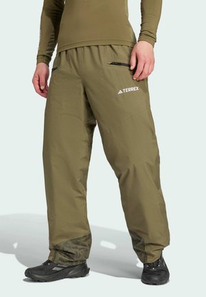 Pantalons Terrex olive en matériau léger et durable, avec une taille élastique, des poches zippées et des accents décoratifs aux poignets.
