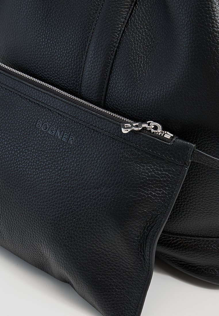 Schwarze, genarbte Lederhandtasche mit einer vorderen Reißverschlusstasche, die einen silbernen Reißverschluss und ein eingeprägtes Bogner-Logo aufweist.