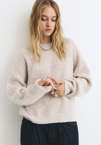 Helles rosa gestricktes Sweatshirt mit gerippter Textur, lockerer Passform und langen Ärmeln. Verfügt über einen weiten Rundhalsausschnitt und seitliche Schlitze.