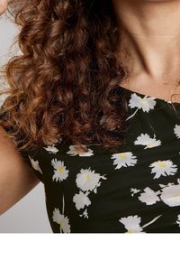 Vestido negro con patrón floral blanco, mangas cortas y escote redondo. Presenta un diseño ajustado y una tela texturizada.