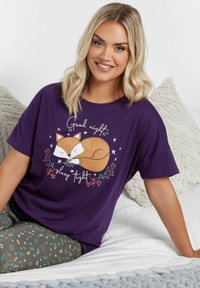 Lila bomull t-shirt med ett grafik av en sovande räv omgiven av blommig accent och texten "God natt, sov gott." Avslappnad passform.