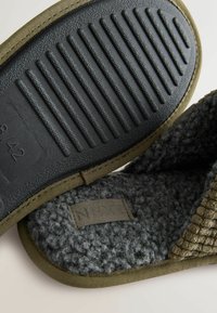 Puchaty szary wełniany kapcie z czarną gumową podeszwą, khaki wykończeniem i teksturowanym cholewką, z etykietą z napisem "NEXT".