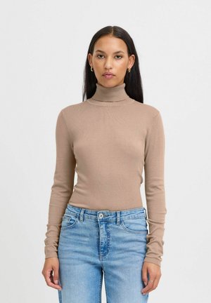Maglione girocollo beige in tessuto a costine, design aderente, maniche lunghe. Abbinato a jeans azzurri chiari, con un classico stile a cinque tasche.