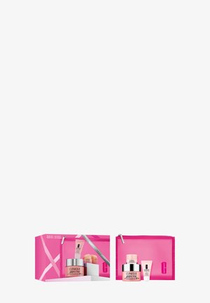 Set de cuidado de la piel Clinique con bolsa rosa con cremallera, crema hidratante con SPF 25, tubo rosa y tubo blanco pequeño sobre fondo blanco.