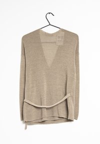 Beżowy sweter dzianinowy z dekoltem w serek i długimi rękawami, z wiązanym akcentem w talii oraz teksturowanym, lekkim materiałem.
