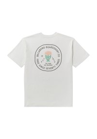 Camiseta blanca de algodón con un diseño gráfico circular en la parte posterior, con elementos textuales e ilustraciones de plantas coloridas.